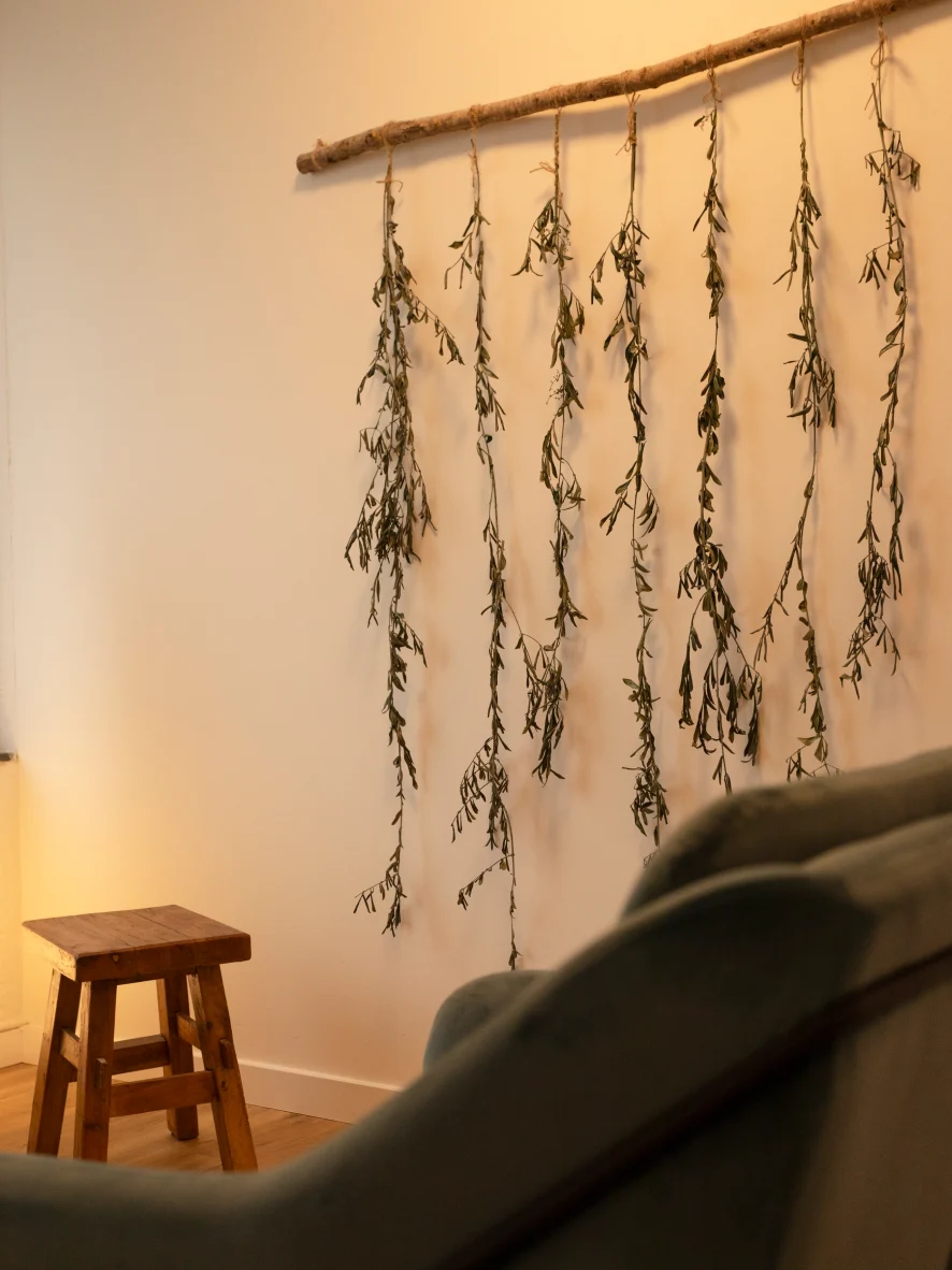Consulting room at Calma de Ser in El Masnou, with an armchair and dried branches on the wall
