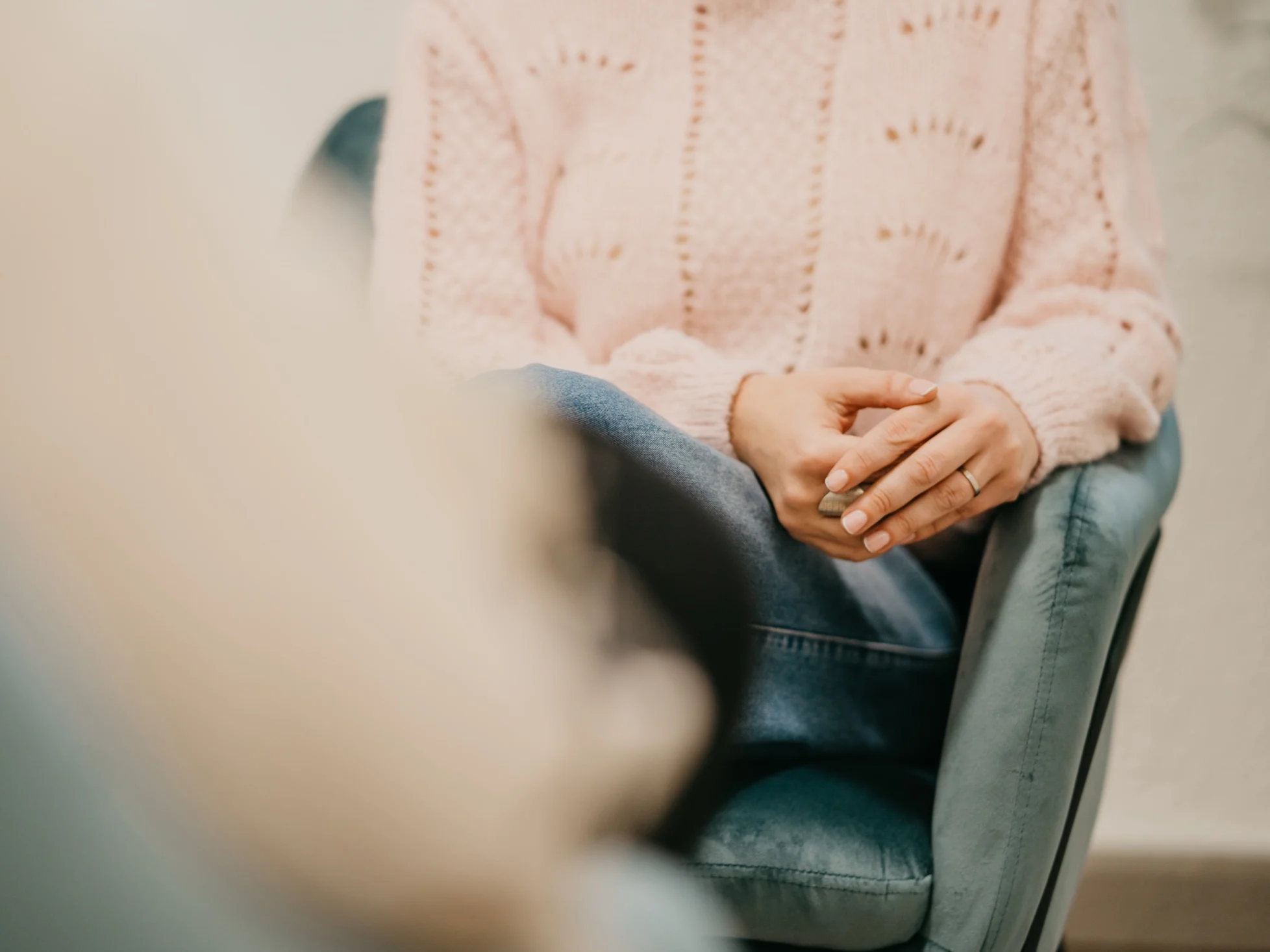A psychologist from the team, sitting in an armchair with her hands clasped